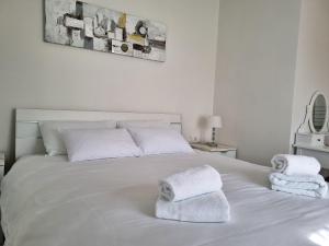 ein Schlafzimmer mit einem weißen Bett und Handtüchern darauf in der Unterkunft Juli No 2 in Poreč