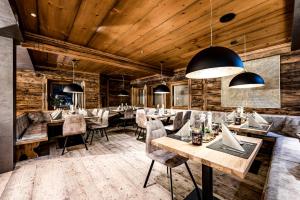 un ristorante con pareti e tavoli in legno e sedie di ALMMONTE PRÄCLARUM SUITES Design Hotel a Wagrain