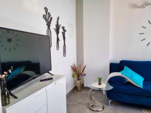 ein Wohnzimmer mit einem blauen Sofa und einem TV in der Unterkunft Juli No 2 in Poreč