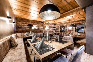 restauracja z drewnianymi ścianami, stołami i krzesłami w obiekcie ALMMONTE PRÄCLARUM SUITES Design Hotel w mieście Wagrain