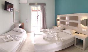 a bedroom with two beds and a window at Giannis Studios in Alykes