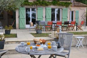 a table with a plate of food and orange juice at Villa with 5 Bedrooms and Private Pool in Grimaud
