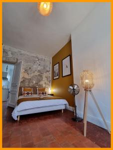 a bedroom with a bed and a lamp in it at Gîtes du petit familistère Landrecies in Guise