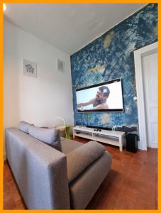 sala de estar con sofá y TV de pantalla plana en Gîtes du petit familistère Landrecies, en Guise