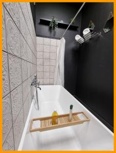 a bathroom with a sink with a soap dispenser on it at Gîtes du petit familistère Landrecies in Guise