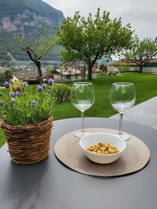 un tavolo con due bicchieri di vino e una ciotola di cibo di Al Ronchetto a Riva San Vitale