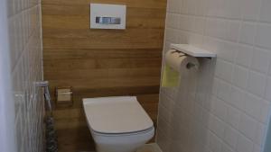 a bathroom with a toilet and a toilet paper dispenser at Rock&Wood Cozy House in Hangzhou