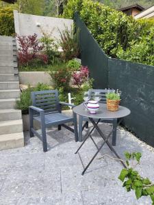 un patio con tavolo, panca, tavolo e sedia di Al Ronchetto a Riva San Vitale