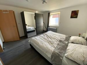 ein Schlafzimmer mit einem Bett und einem großen Spiegel in der Unterkunft Ferienwohnung zum Pinguin 3 in Wiednitz