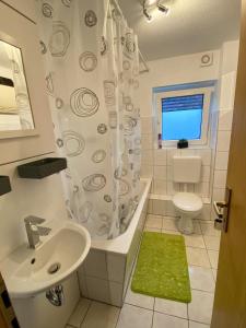 ein Badezimmer mit einem Waschbecken, einer Badewanne und einem WC in der Unterkunft Ferienwohnung zum Pinguin 3 in Wiednitz