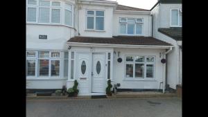 a white house with white doors and windows at Room in Guest room - Apple House Wembley - Family room with shared bathroom in Edgware