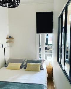een slaapkamer met een bed met twee kussens en een raam bij Villa les Fleurs Appartement en front de mer in Mers-les-Bains