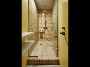 een badkamer met een douche en een tegelvloer bij 9h nine hours woman Shinjuku in Tokyo