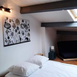 a bedroom with a bed and a painting on the wall at Maison de ville in Vic-le-Comte +25 photos