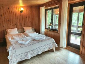 sypialnia z łóżkiem w pokoju z oknami w obiekcie Dom Wakacyjny z ogromnym ogrodem w mieście Witaszyn