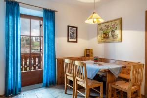 a dining room with a table and chairs and a window at Sallrain Hof Apartment 1 in Collalbo