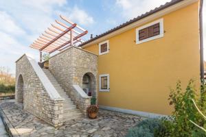 a yellow house with a stone stairway at Apartment SENA in Vodnjan