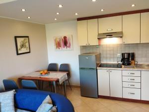 a small kitchen with a table and a refrigerator at Apartment SENA in Vodnjan