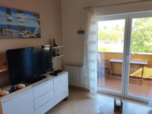 a living room with a flat screen tv on a white cabinet at Apartment SENA in Vodnjan