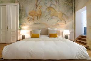 a bedroom with a bed with a painting on the wall at La Calamande En Ville in Brussels