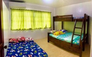 a bedroom with two bunk beds and a chair at Deluxe Villa Leah Natural Hotspring Resort in Calamba