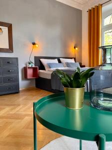 a bedroom with a bed and a table with a potted plant at City Gästeapartment Leipzig Zentrum-Ost in Leipzig