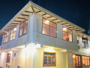 a large white house with windows at night at Lavinia Blue Hotel in Mount Lavinia