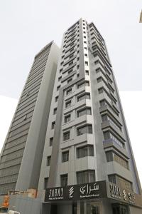 科威特Saray Prime Suites的一座高大的灰色建筑,上面有标志