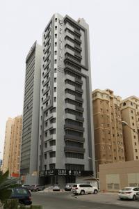 Saray Prime Suites في الكويت: مبنى كبير به سيارات تقف في موقف للسيارات