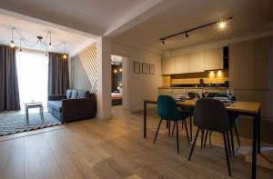 a kitchen and living room with a table and chairs at Olimpia Residence District Satu Mare in Satu Mare