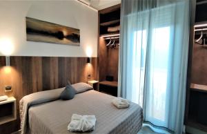 a bedroom with a bed with two towels on it at Hotel Centrale FRONTE MARE in Milano Marittima
