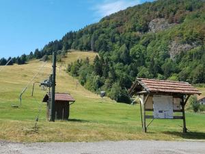 a sign on the side of a field with a mountain at Studio Bussang in Bussang