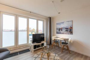 a living room with a television and a table with chairs at Haus Knechtsand, Whg 447 in Duhnen