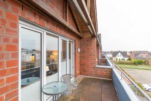 a balcony with a glass table and a window at Haus Knechtsand, Whg 447 in Duhnen