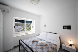 Habitación blanca con cama y ventana en WePuglia - Dimora Capitolo, en Monopoli
