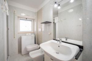 a white bathroom with a sink and a toilet at WePuglia - Dimora Capitolo in Monopoli