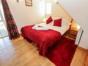 a bedroom with a bed with a red blanket at Dove Cottage in Hexham
