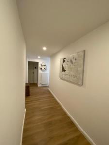 a hallway with a white wall with a painting on it at Budget in Westerland