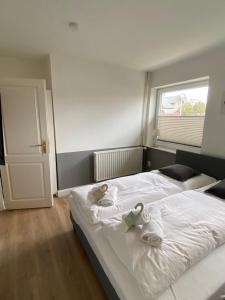 Un dormitorio con una cama blanca con toallas. en Budget, en Westerland