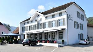 a white building with a car parked in a parking lot at Monteurzimmer ZIMMERzuVERMIETEN Oensingen in Oensingen