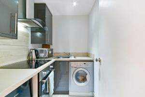 a kitchen with a washing machine in the middle at South Kensington Studio in London