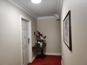 un corridoio con un vaso di fiori su un tavolo di Aran View Country House a Doolin