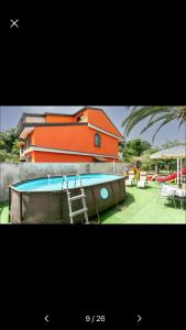 um edifício com piscina em frente a uma casa em Casa vacanza tra Etna e Taormina Villa Ginevra em Piedimonte Etneo