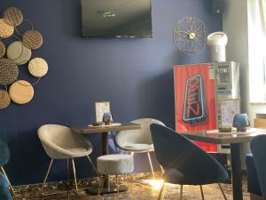 a room with two tables and chairs and a blue wall at Hotel Post Sindelfingen in Sindelfingen