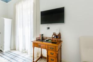 Televízia a/alebo spoločenská miestnosť v ubytovaní Palazzo Montalbano