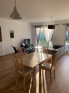 a dining table and chairs in a living room at Grande maison neuve idéale pour 6 personnes in Saint-Loubès