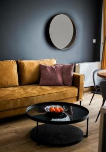 a living room with a couch and a round mirror at Apartamenty STUDIO in Busko-Zdrój