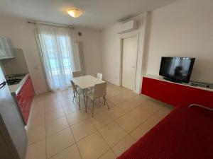 una cucina e una sala da pranzo con tavolo e TV di Residence Al Mare - Agenzia Cocal a Caorle