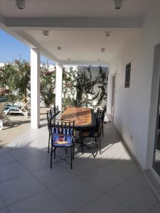 un patio con mesa y sillas en un porche en Résidence Fleur de la petite côte en Mbour