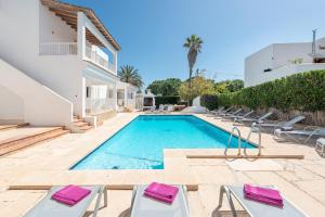 una villa con piscina e sedie a sdraio di NEW! Apartment SUNSET 1, Pool, AC, BBQ, Wifi, Cala D'or, Mallorca a Cacla D'or